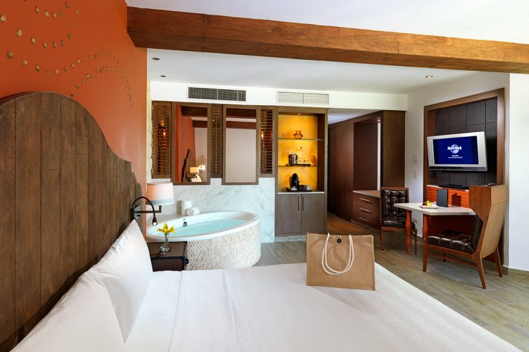 The interior of a Deluxe Gold king bed room with a jacuzzi in the background.