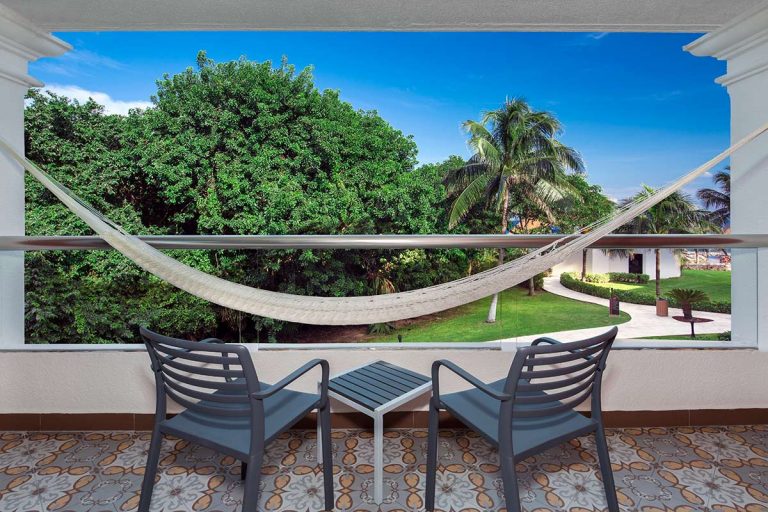A Deluxe Gold Suite Balcony with a sitting area and hammock.