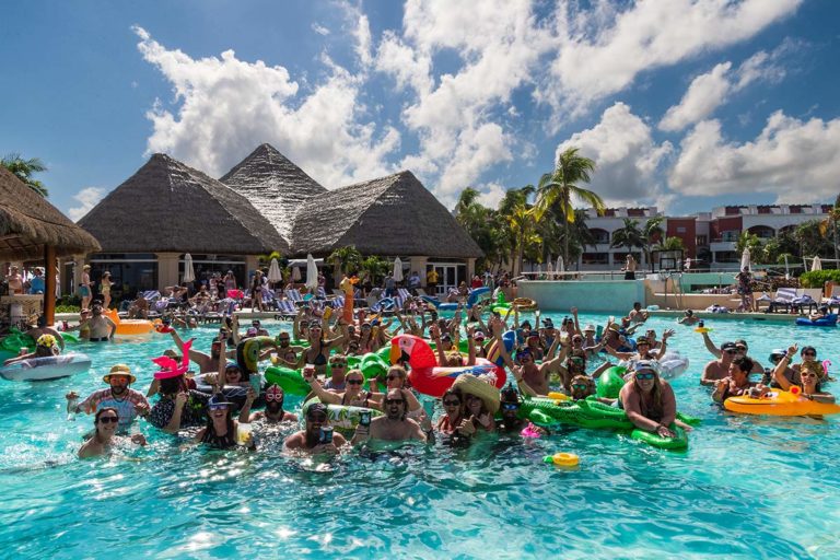 A group of guests with pool floats posing for a photo