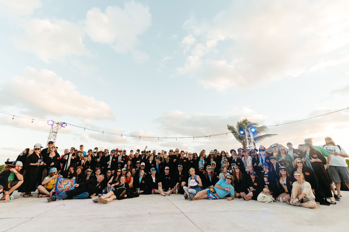 A group photo of guests in their Playas Club black loyalty robes