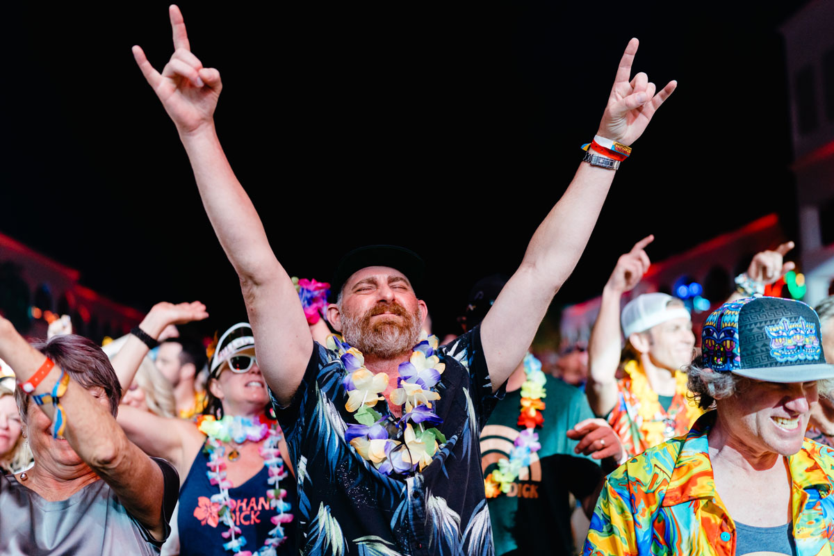 A guest posing with their hands up in the crowd.