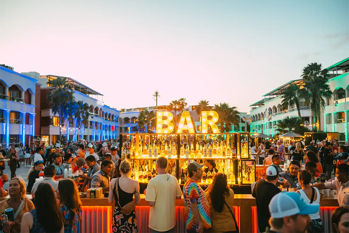 The main concert courtyard bar during sunset with guests ordering drinks.
