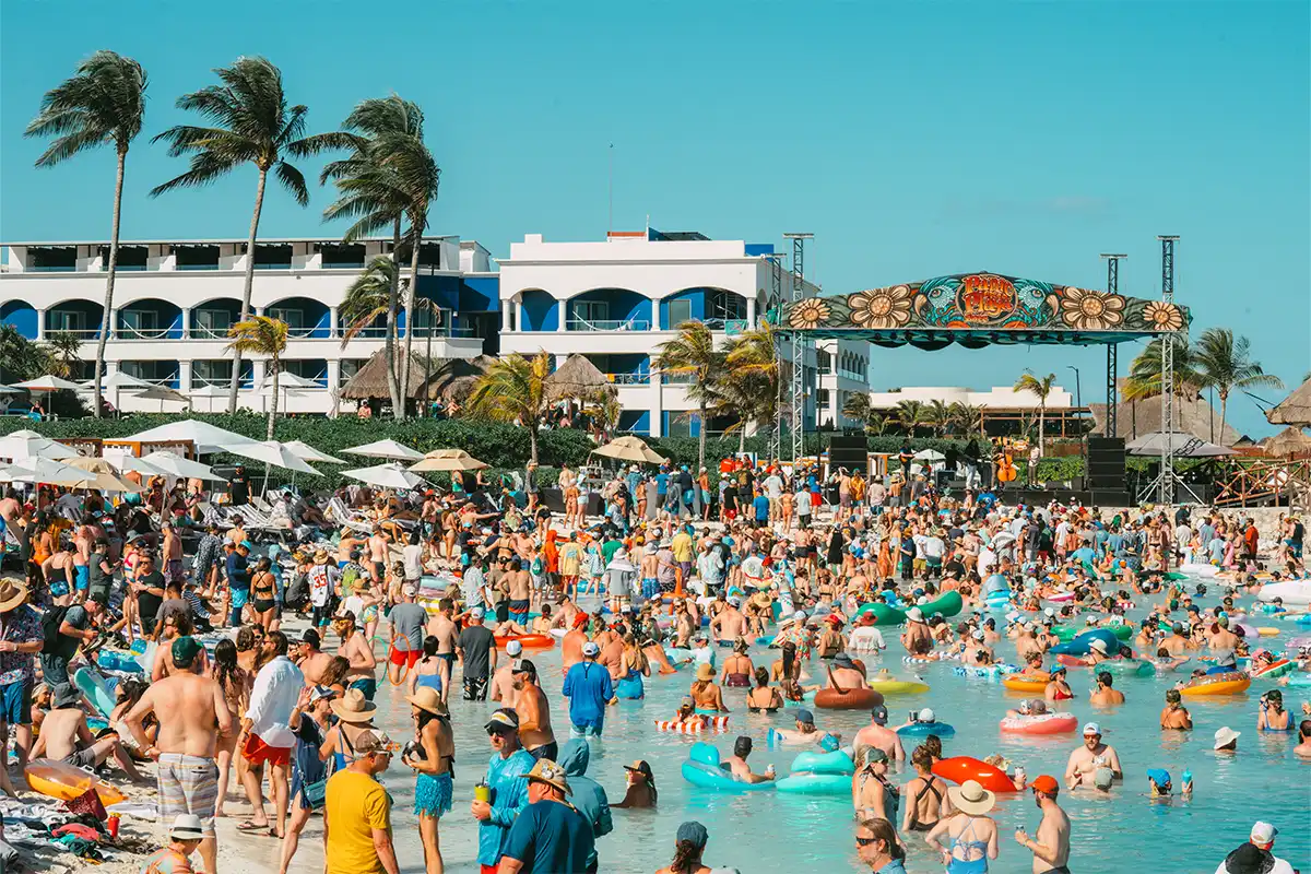 Wide angle photo of the guests floating in a lagoon with the Beach Stage in the background.