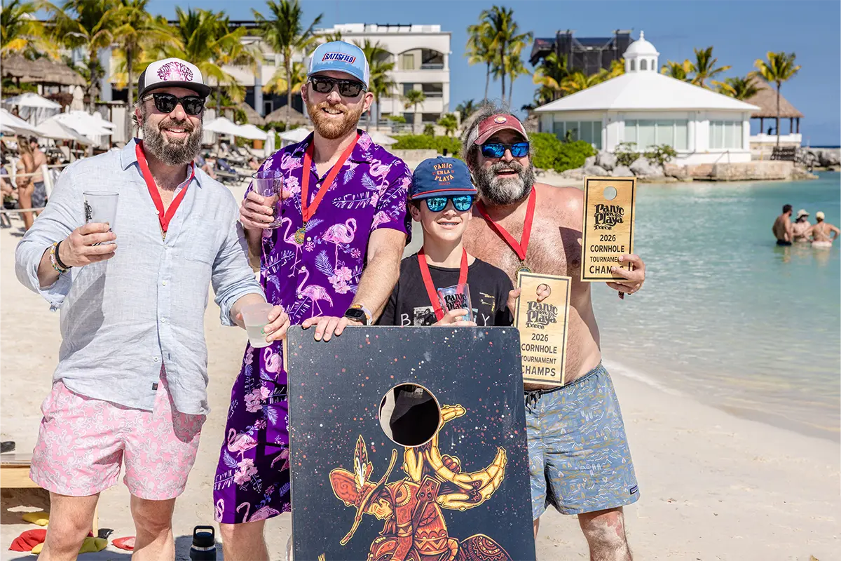 Guests posing with mini cornhole board trophies