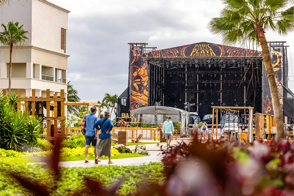 Guests walking in the Concert Courtyard with the Main Stage in the background.